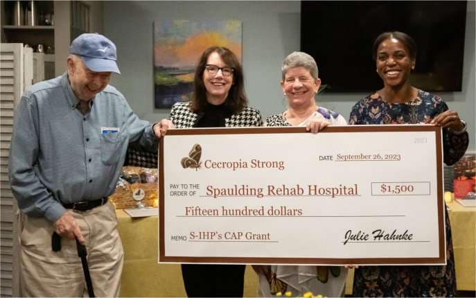 Charlie Phillips and Nancy Phillips Marshall (who together make up the Phillips Family, who funds these grants), Julie Hahnke, and Esther Ayuk, who's accepting this check on behalf of Spaulding Rehab Hospital and IHP.