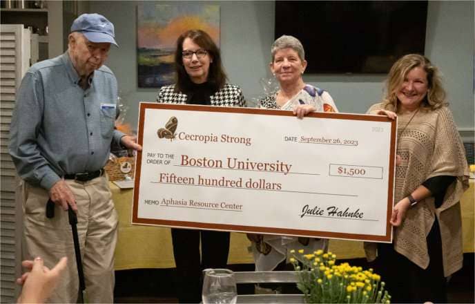 Charlie Phillips and Nancy Phillips Marshall (who together make up the Phillips Family, who funds these grants), Julie Hahnke, and Liz Hoover, who's accepting this check on behalf of BU's Aphasia Resource Center.