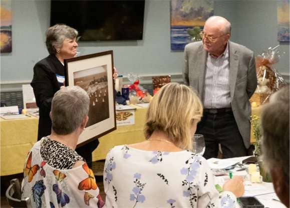 Jessica Barnett, playing Vanna White, supporting Gene Arnould our Auctioneer.