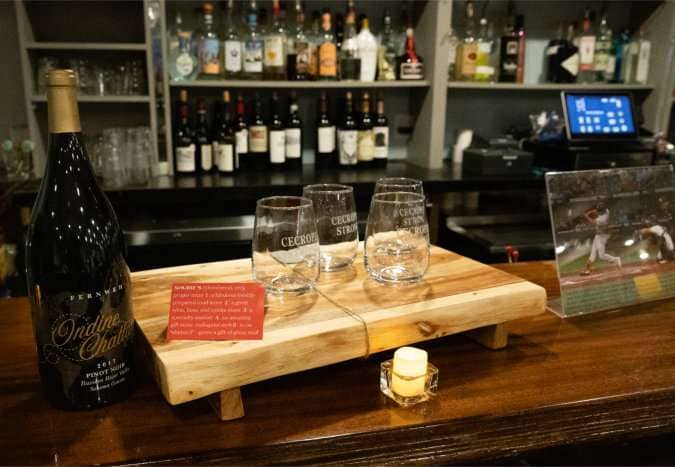 A Live Auction item - a magnum of select Pinot Noir with 4 stemless wine glasses, a charcuterie board, and a $100 gift card to Shubies to buy the sausages, cheeses, and toppings of your choice.